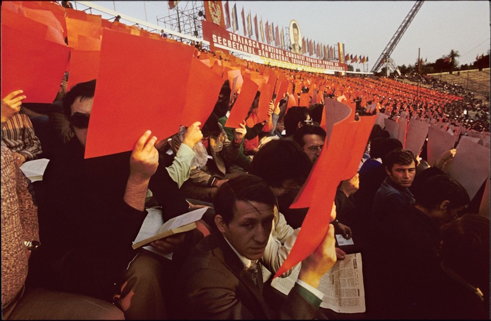 Romanians hold up coloured paper to form a giant human flag during a Ceausescu-era national holiday