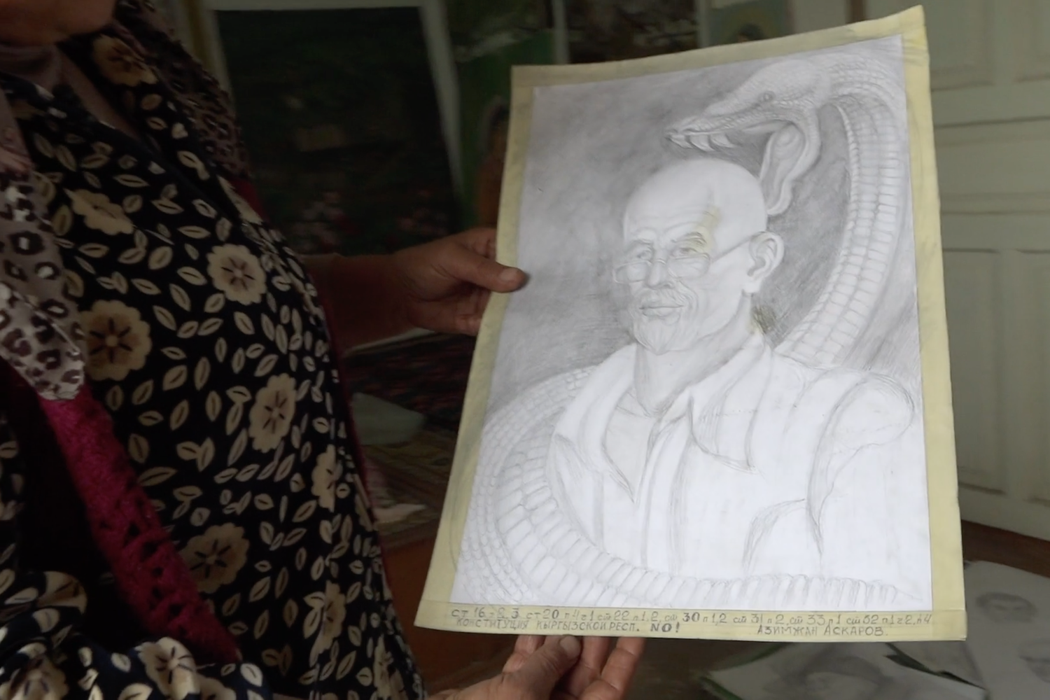 Khadicha holding Azimjan's self-portrait.