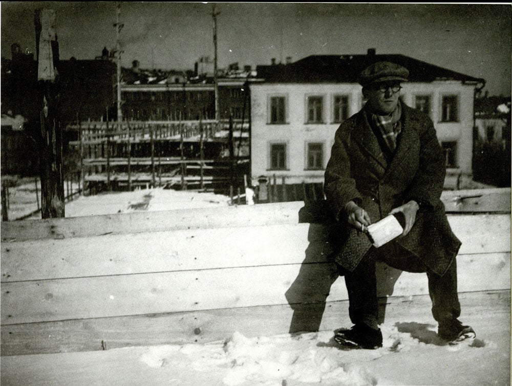 Le Corbusier sits in the snow in front of the Tsentrosoyuz building construction site in 1931