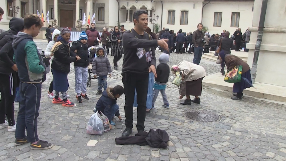 Alexandru Solomon throws money to the ground outside the Bucharest Orthodox Cathedral as part of his performance-protest