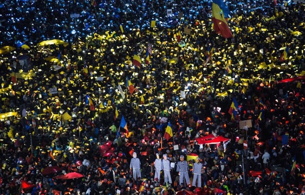 Protesters in Bucharest hold up coloured lights and objects to create the image of the Romanian flag during recent anti-corruption protests. Image: Ioana Moldovan