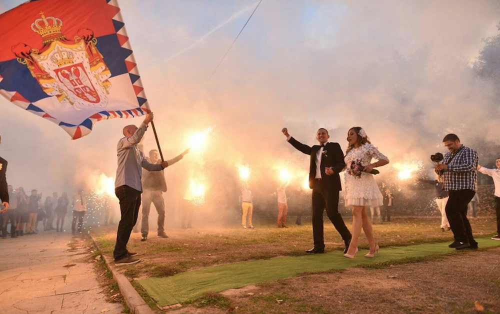 Rapper Marlon Brutal is greeted by football flares and a monarchist flag at his New Belgrade wedding. Image: marlonaldo21/Instagram