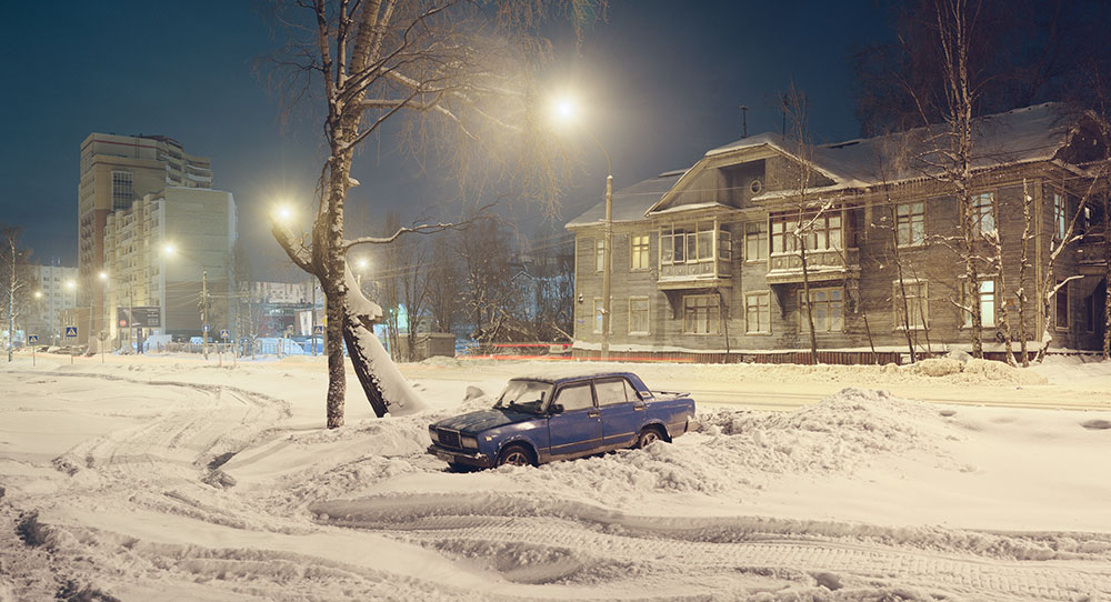 Snow transforms the dark northern nights, reflecting pale streetlight into the sky.