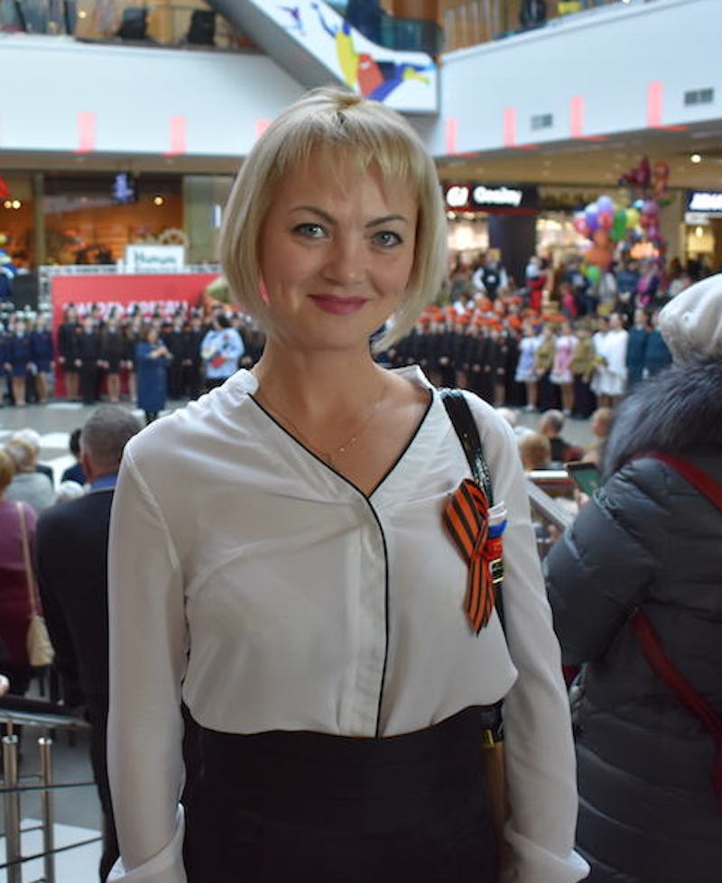 Teacher Irina Kirpikova watches as her pupils perform war-themed songs and dances in a shopping mall