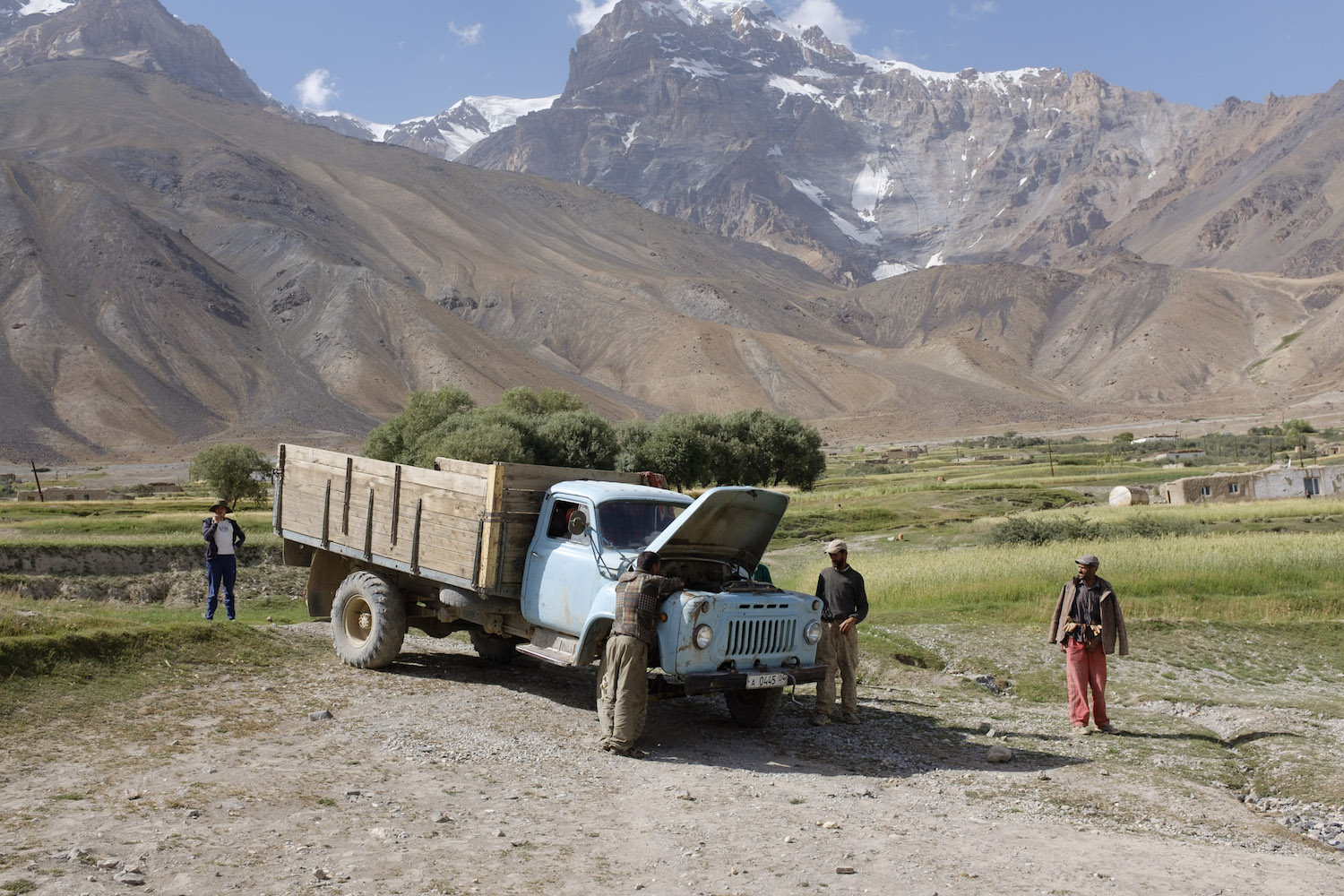 Men gather around a truck. Many vehicles fail to make the arduous journey through the Pamirs