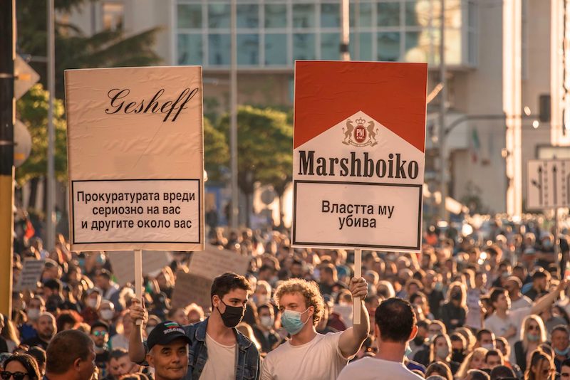 Two posters styled as cigarette packets. The right poster plays on the brand name Malboro to write, "Get out [Prime Minister] Borissov". The warning reads, "His power kills".