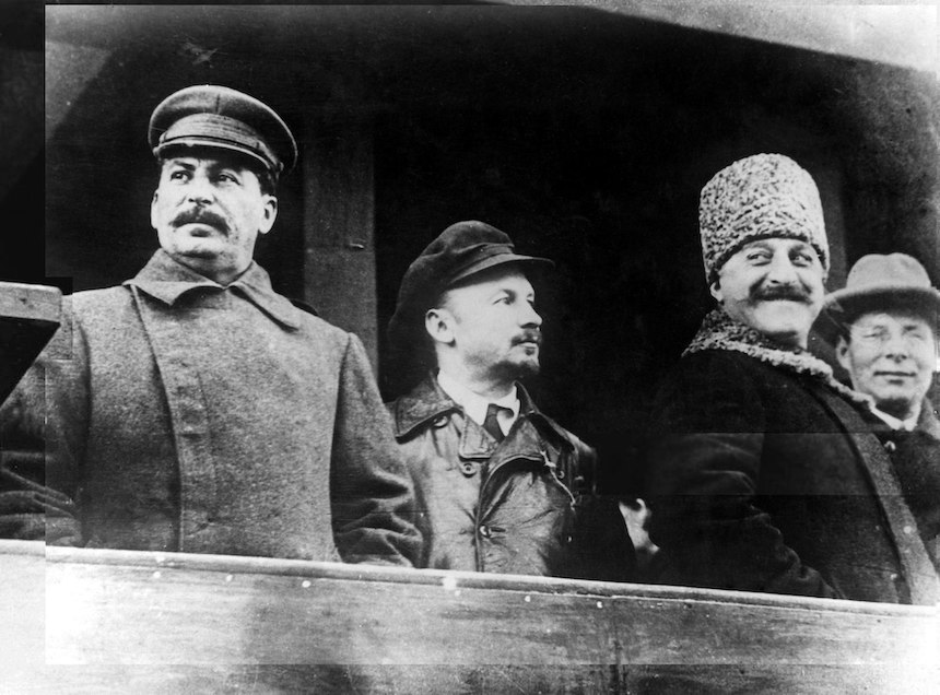 Stalin, together with Nikolai Bukharin, Sergo Orjonikidze, and Jānis Rudzutaks, look out over Red Square in 1929