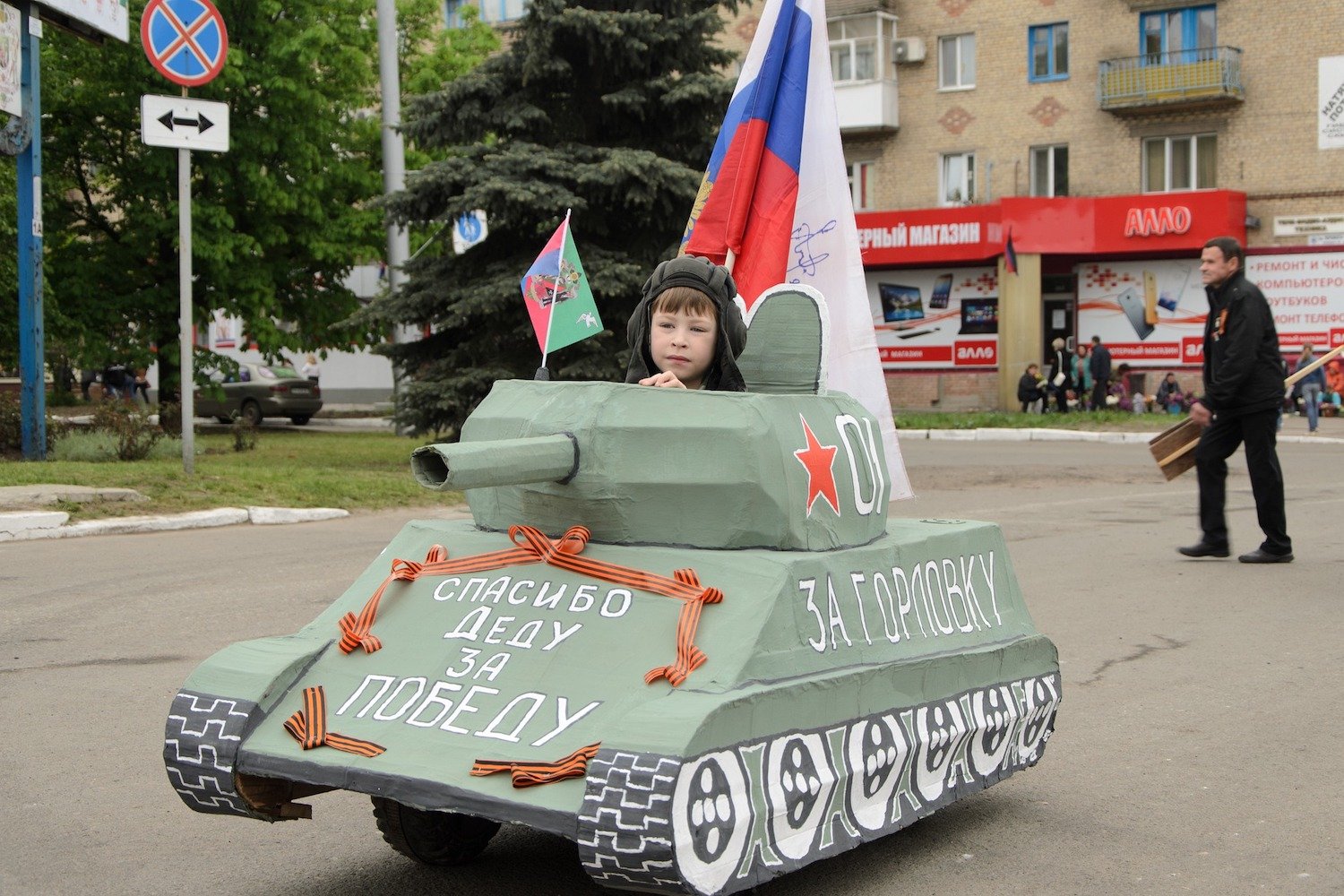 A boy drives a toy tank on Victory Day. The front reads, "Thank you, Grandad, for victory." Image: Don 69/Pixabay under a CC licence.