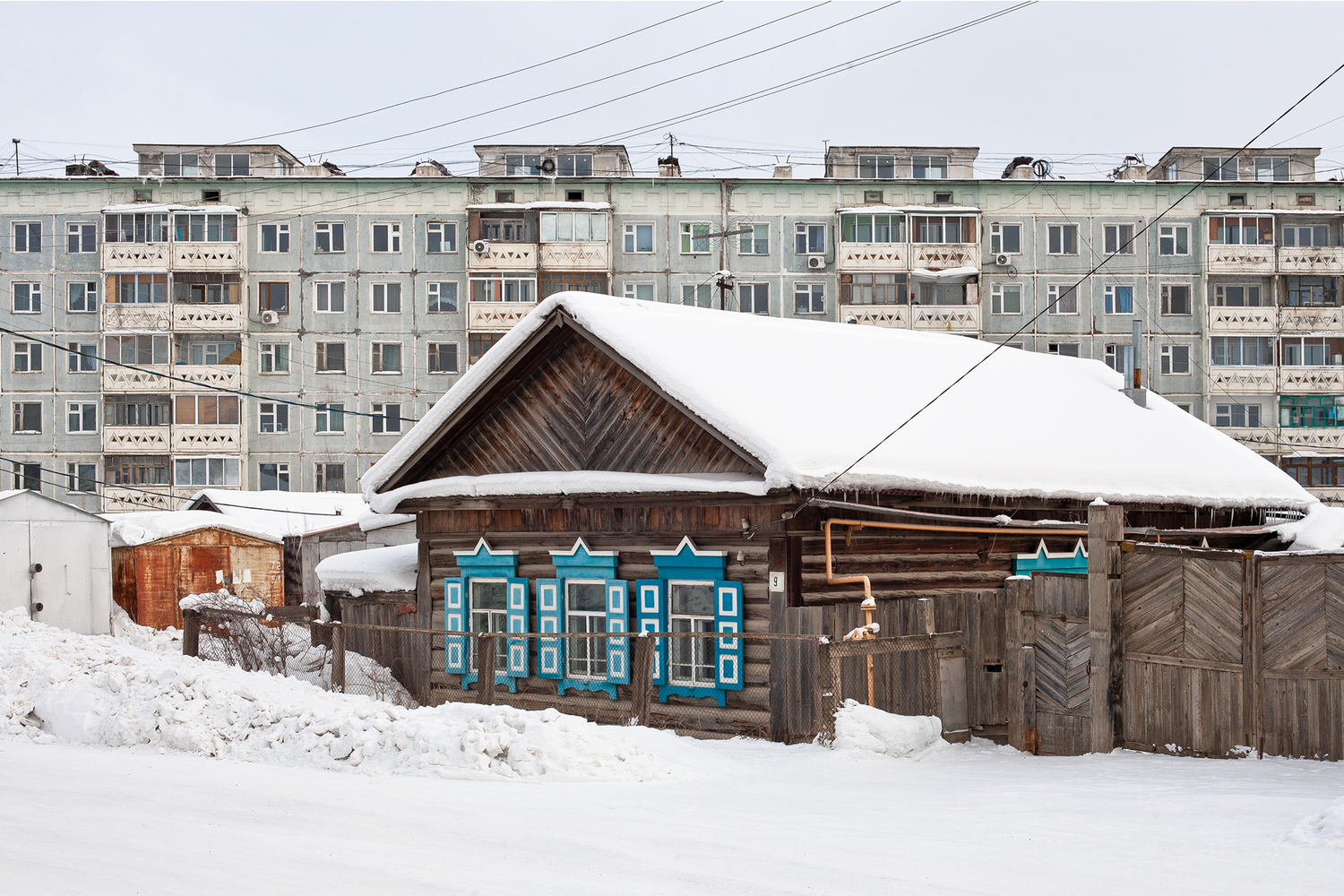 A typical Yakutian Izba and a prefab panel block from the late 1980s. Image: Zupagrafika 