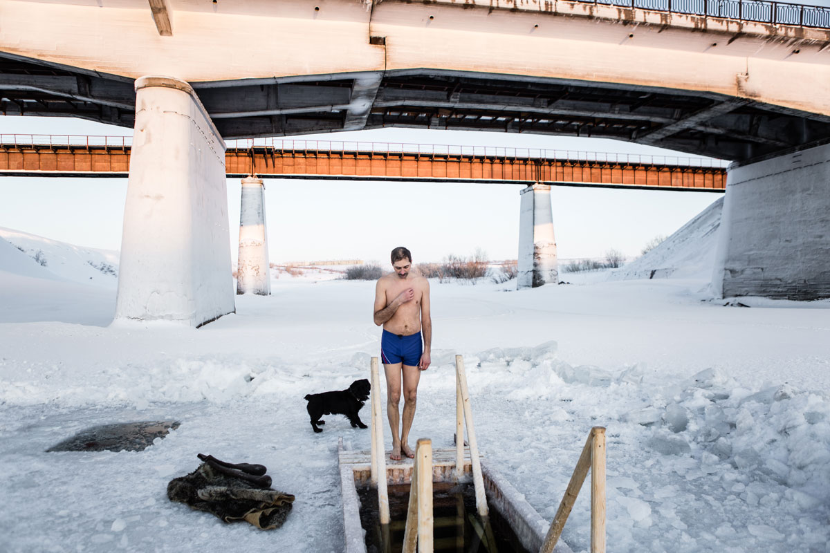 A man prays before dipping into an ice hole 