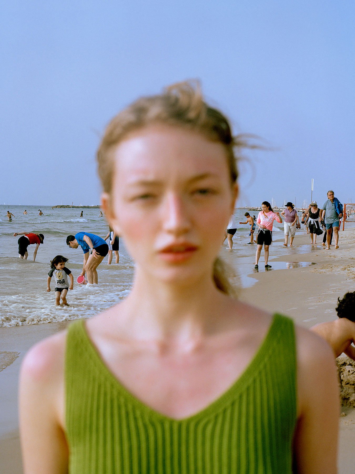 <p>Emmie America often works with fashion photography, but portraiture, movement and capturing each person’s character is central to her practice. This photo was taken on a beach in Tel Aviv, reflecting its hectic surroundings in the blazing sun. </p>
