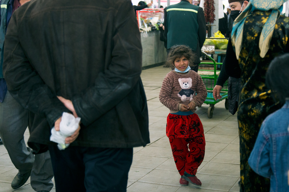 A child clutches a toy on a street in Tashkent. Image: Kamila Rustambekova