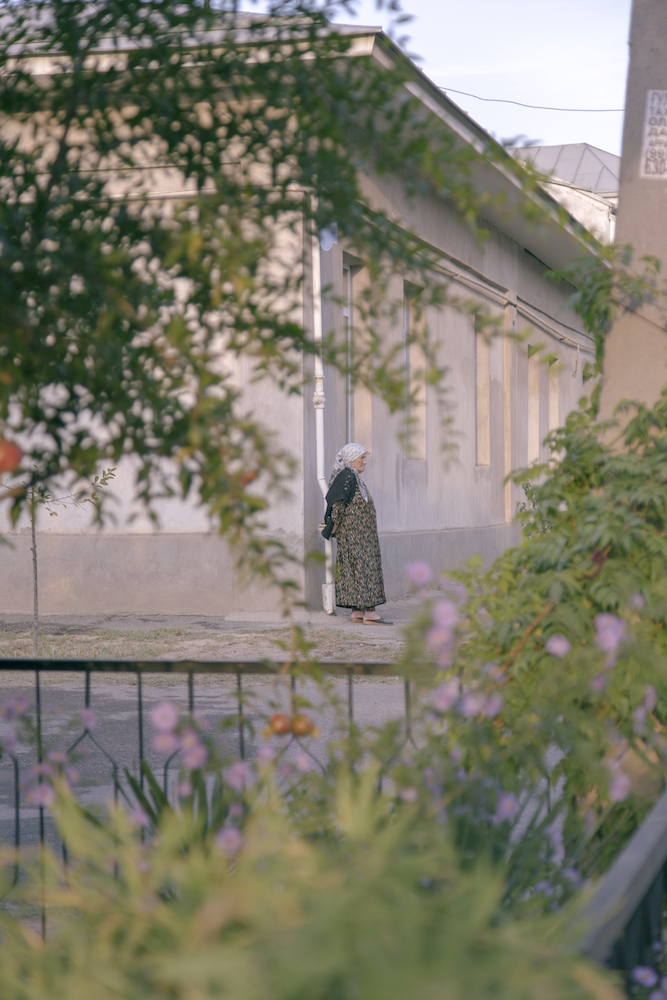 An elderly woman waits on a street corner in Tashkent. Image: Kamila Rustambekova