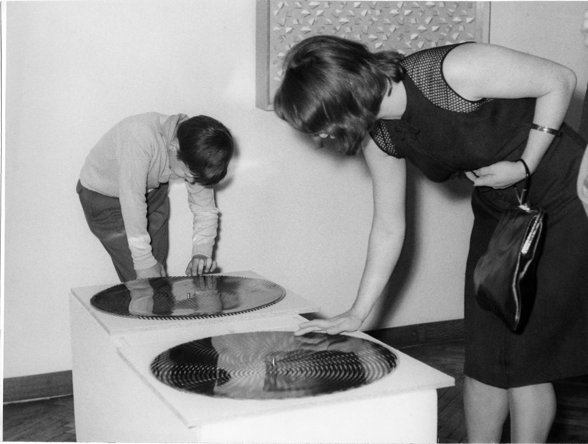 Visitors manipulating Drehgraphik by Rudolph Kämmer with the work by Klaus Staudt Regelmässig grau-weiss in the background