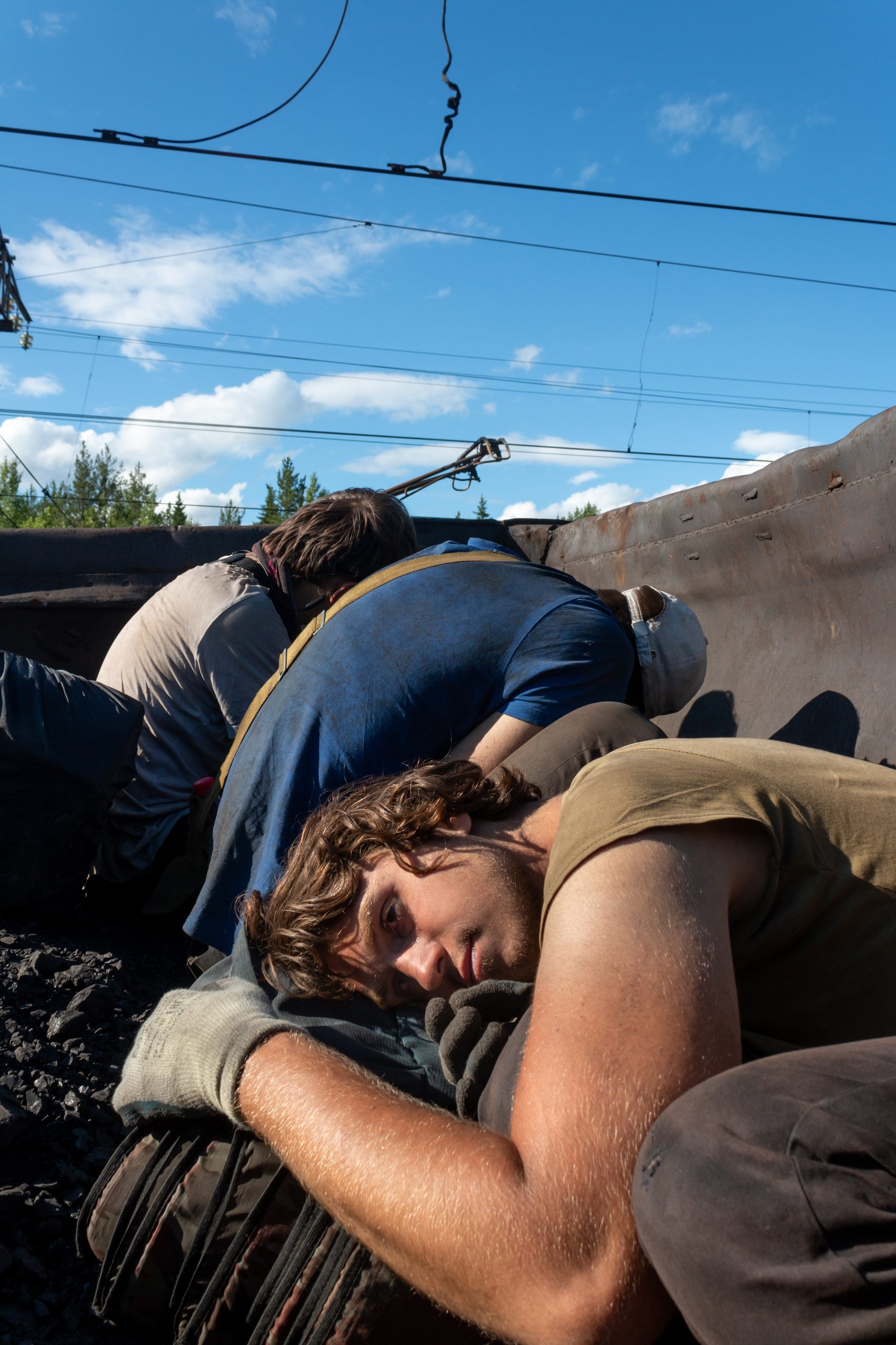 Edik, Roma, and Danya hiding from the locomotive standing just beside their wagon. If the driver sees them, they might get reported and detained.