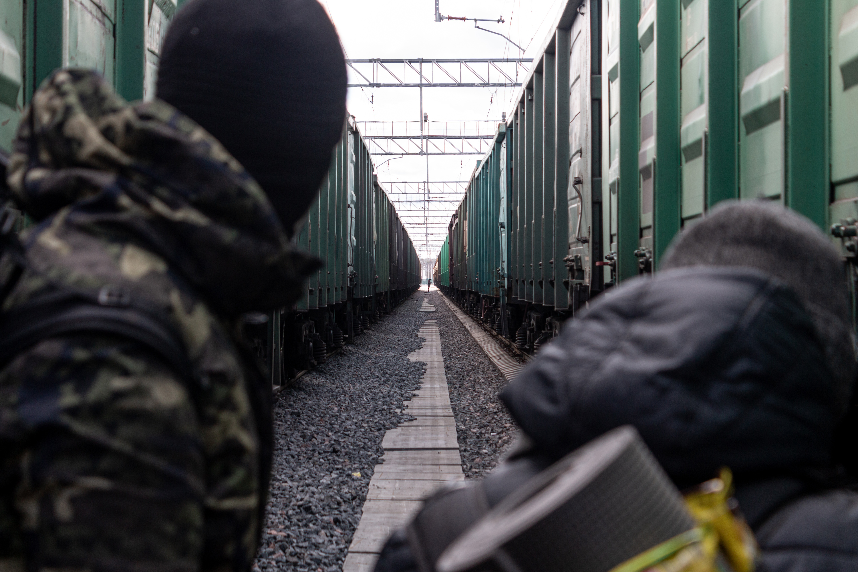 Artem and Maxim watching an unidentified person between the tracks in the rail yard. If a staff member sees them, they might report to the head of the station, and the guys will be detained by security.