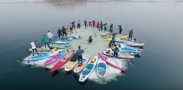 Vladivostok flash mob turns ice sheet into giant paddle board